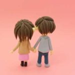 手をつないで歩くカップルの後ろ姿